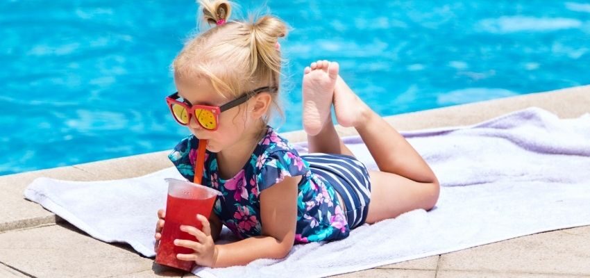 A child sipping drinks by the pool.
