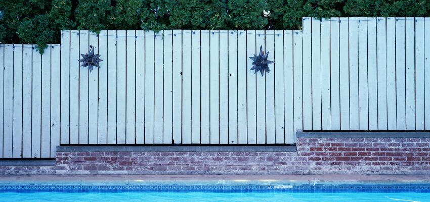 Painted wooden fences are one of the most basic pool fence ideas.