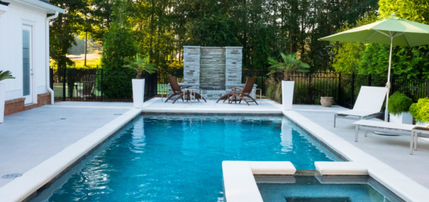 Install privacy screens using natural materials like bamboo or tall shrubs to create a secluded and low maintenance pool area.