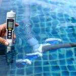 The pool owner checks the pool's salt level.