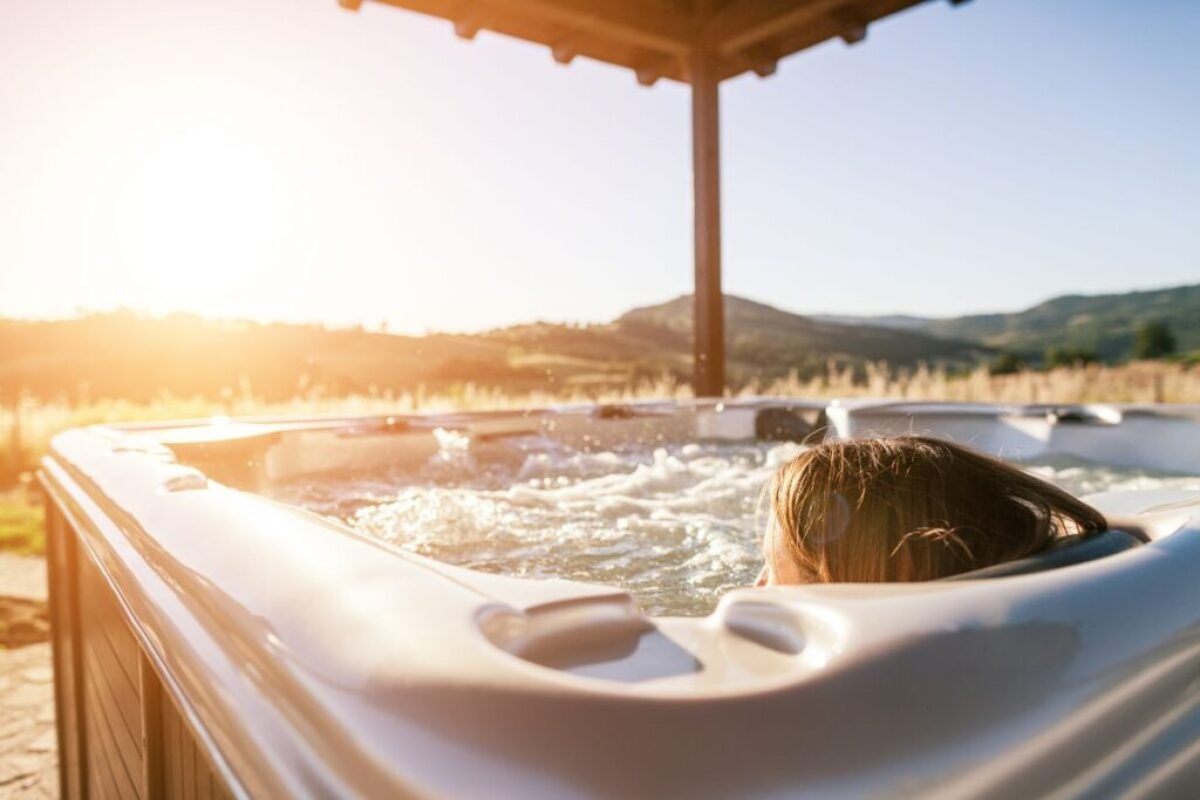 A woman is relaxing in a fiberglass hot tub.