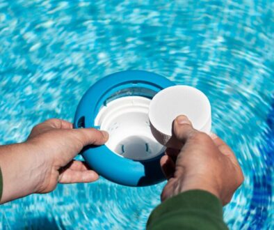 The pool owner places chlorine tablets in the skimmer basket.