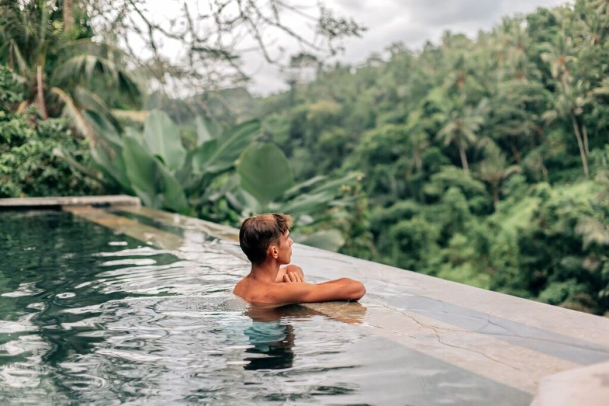 The man is swimming in a fiberglass infinity pool.