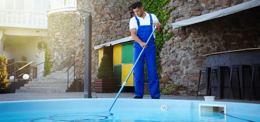 An expert cleans the sediment from the bottom of the pool.