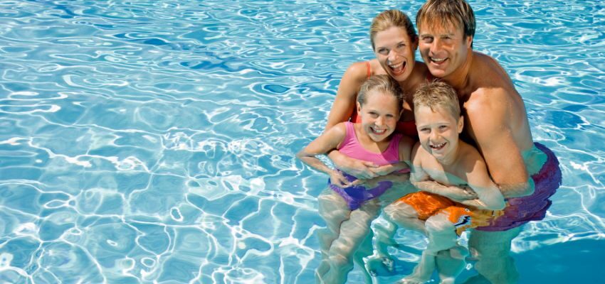 A happy family swimming in a saltwater pool.