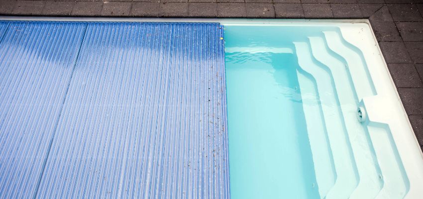 A pool cover reduces heat loss by preventing evaporation and retaining warmth. This allows your heat pump to work less and save energy.