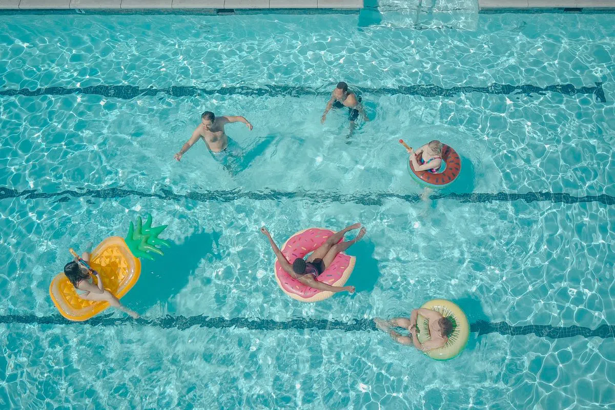 The group of friends is having fun swimming in a pool.