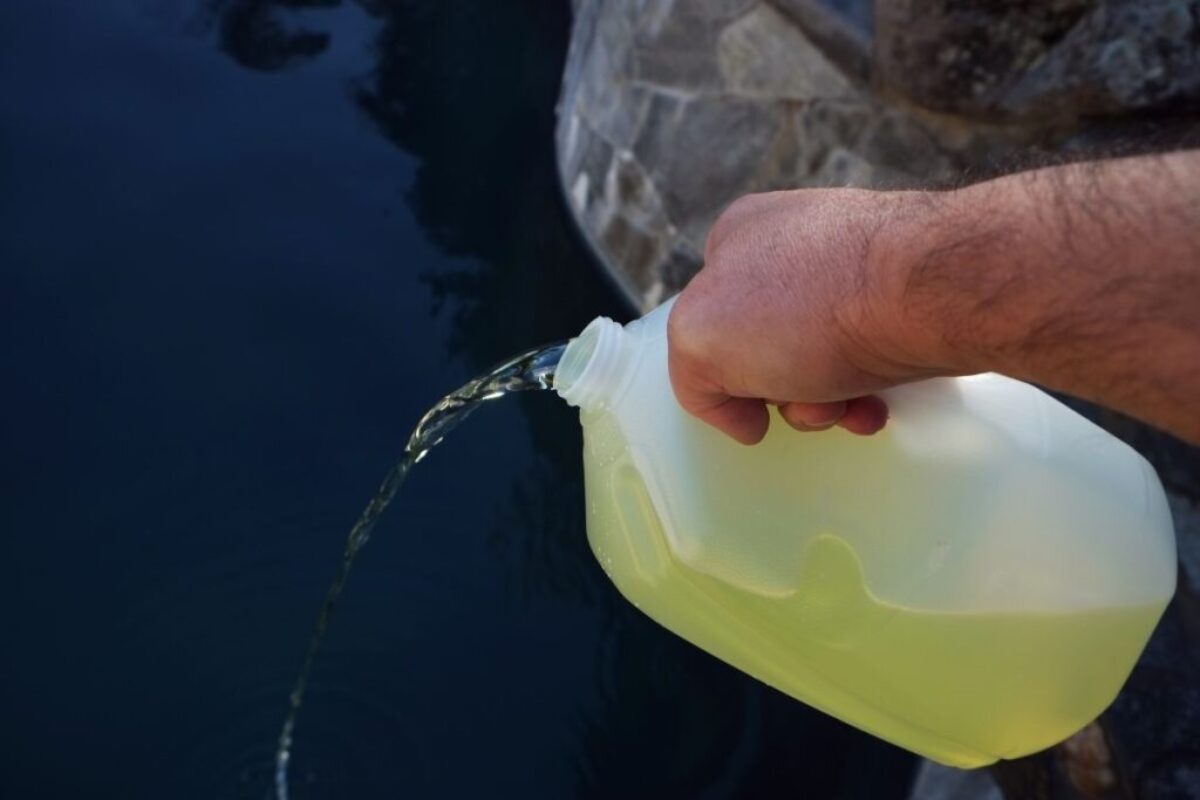 The homeowner adds liquid chlorine to the pool water.