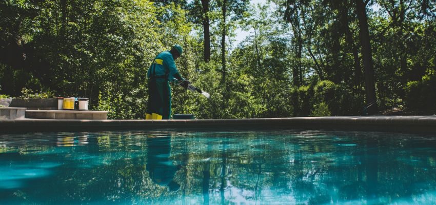 The man puts the chemicals needed for the pool above ground to avoid the algaecide.